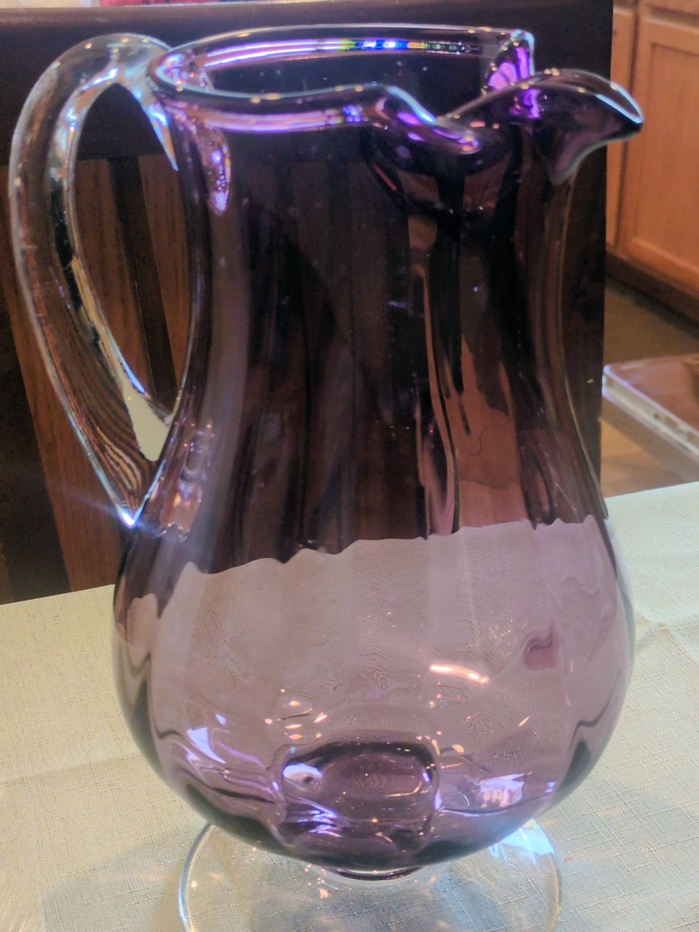 Vintage Viking Glass amethyst purple glass pitcher with a clear handle.